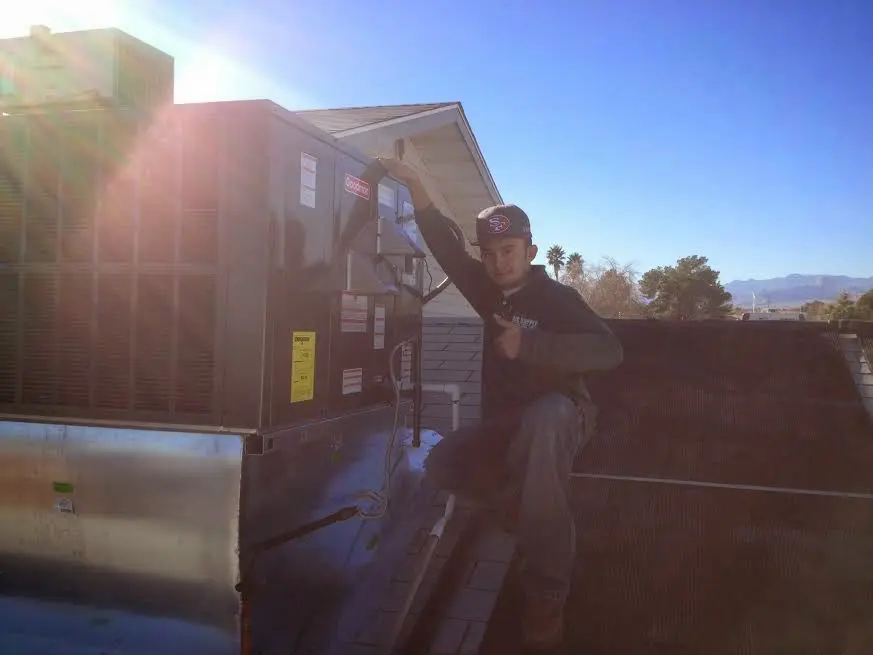 HVAC technician performing Air Duct Repair on a rooftop unit in Schuylkill